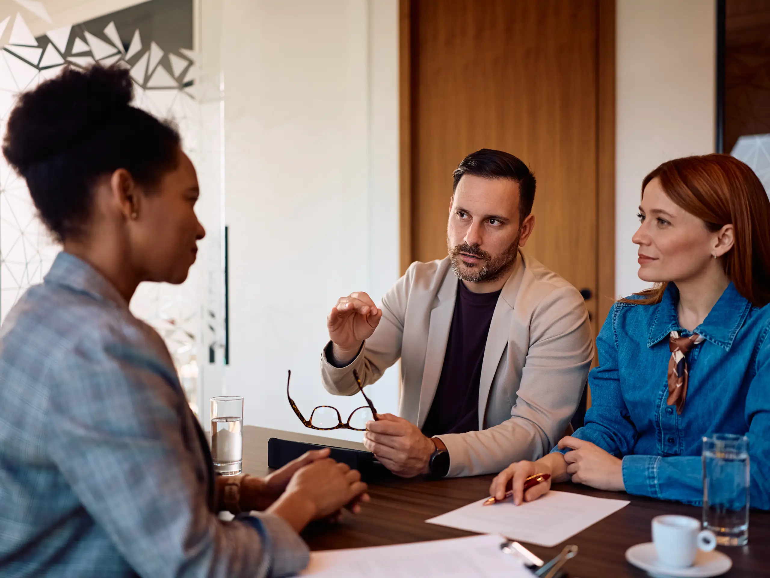 A borrower meeting with a banker at a desk while reviewing loan documents